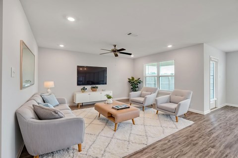 A living room with a grey sofa, a wooden coffee table, and a ceiling fan.