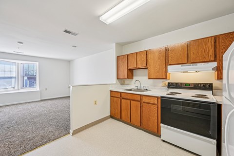 A kitchen with white appliances and wooden cabinets.