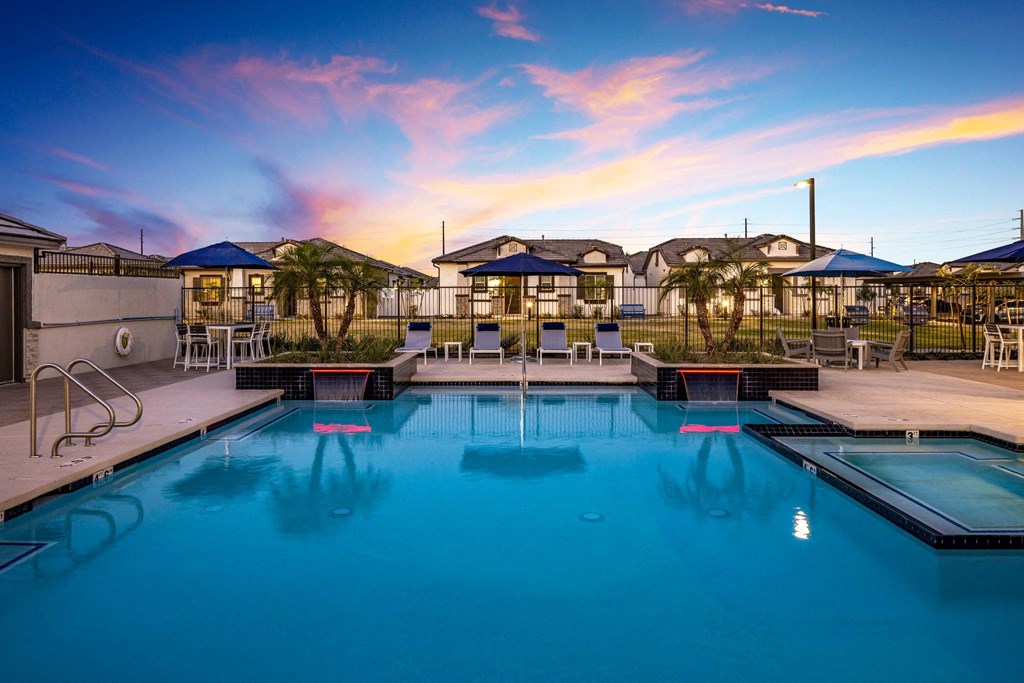 A swimming pool with a sunset in the background.