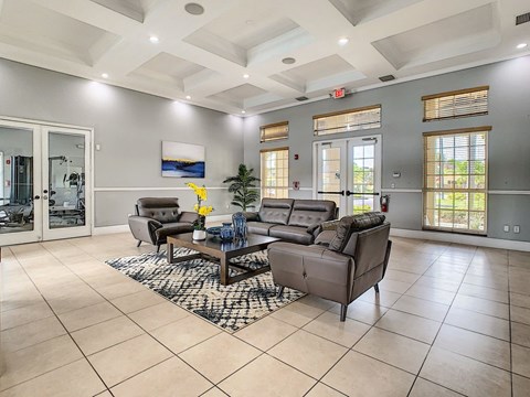 A spacious living room with a large grey sofa set and a coffee table in the center.