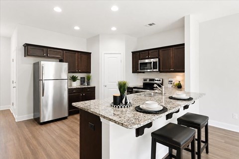 A kitchen with a granite countertop and a refrigerator.