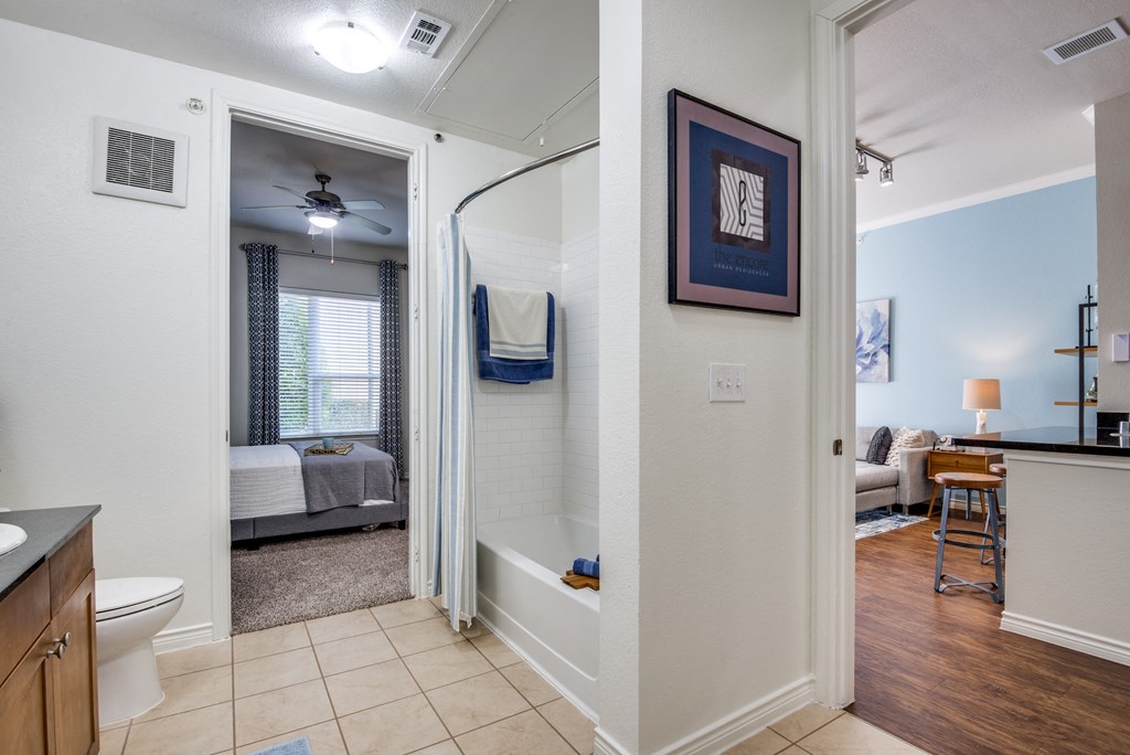 a bathroom with a shower and a living room with a couch