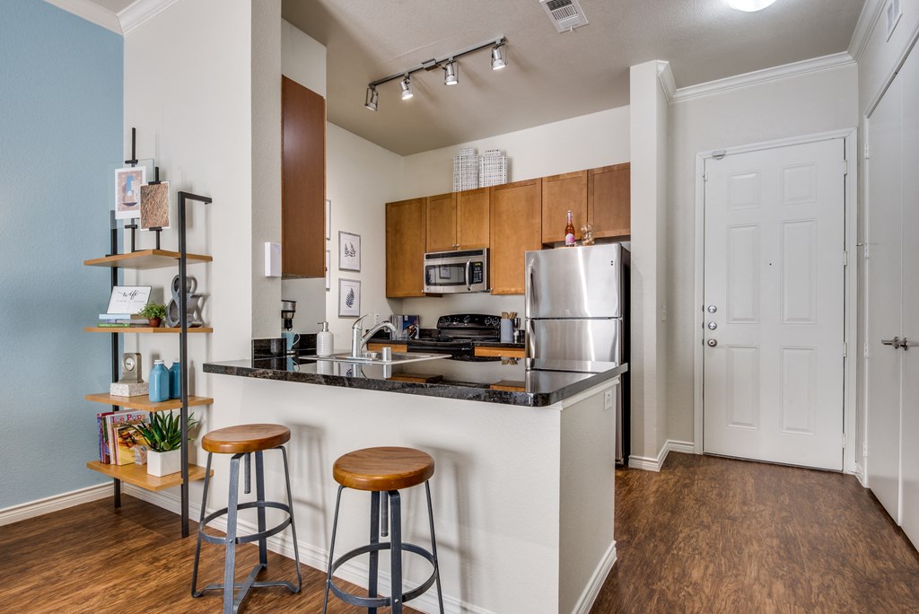 a kitchen with a island and stools and a refrigerator