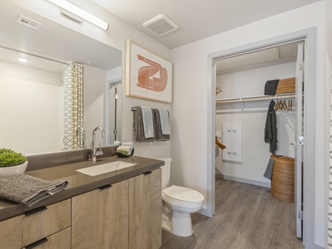 A bathroom with a toilet, sink, and mirror.