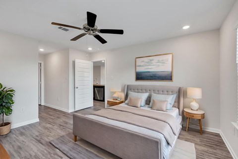A bedroom with a large bed and a ceiling fan.
