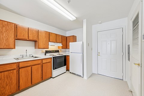 A kitchen with wooden cabinets and white appliances.