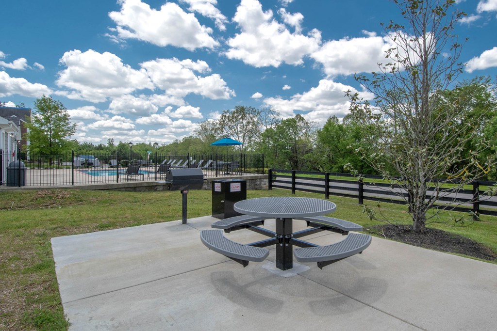 a picnic table in a park next to a pool