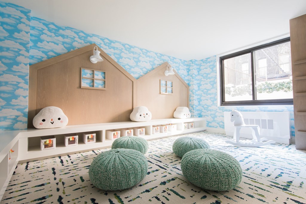 a childs play room with blue and white wallpaper and a wooden toy house
