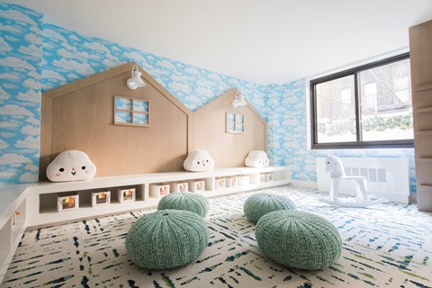 a childs play room with blue and white wallpaper and a wooden toy house