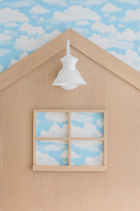 a light fixture in the shape of a barn with a window