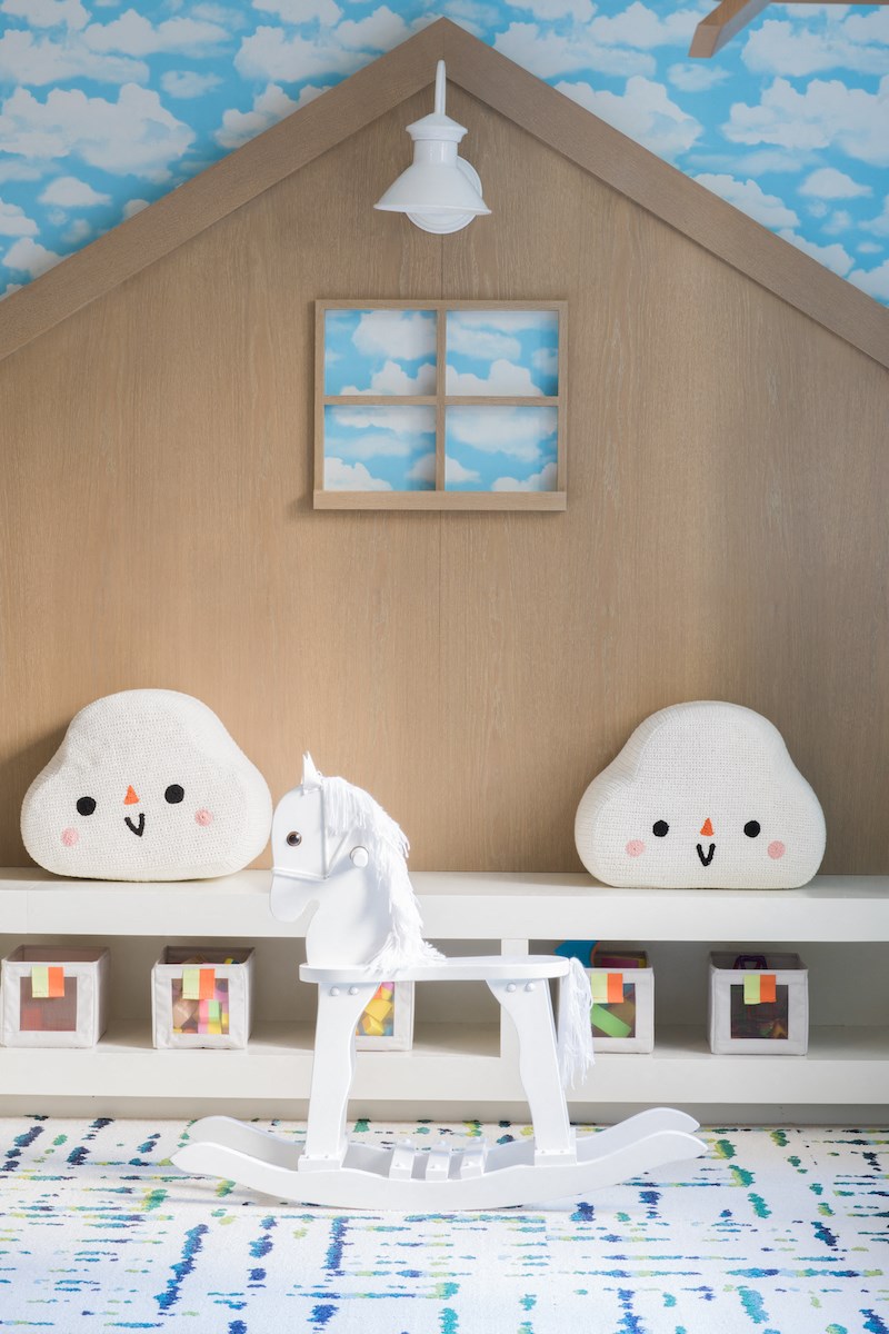 a childs playroom with two chairs and a rocking horse and a toy house