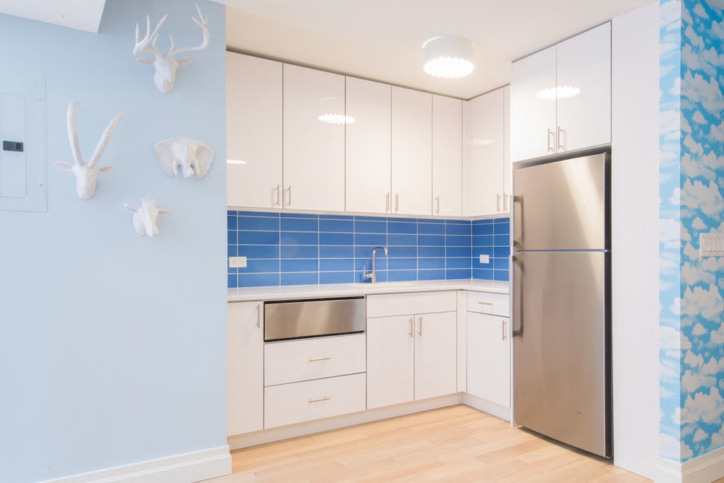 a kitchen with white cabinets and a stainless steel refrigerator