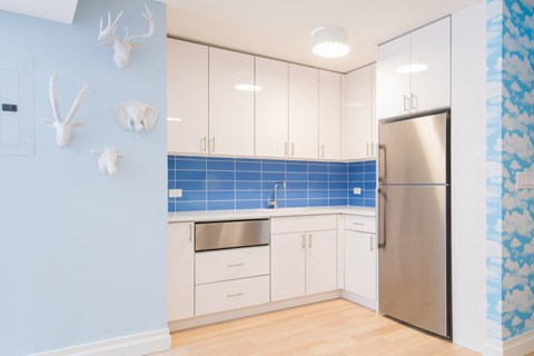 a kitchen with white cabinets and a stainless steel refrigerator