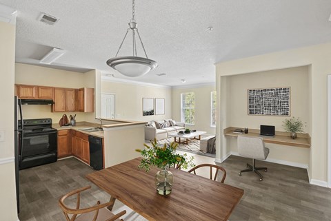 A kitchen with a dining table and chairs in the foreground.