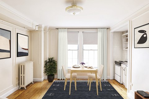 Cozy dining area with a small table set for two, adjacent to a compact kitchen.