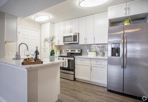 a kitchen with stainless steel appliances and white cabinets