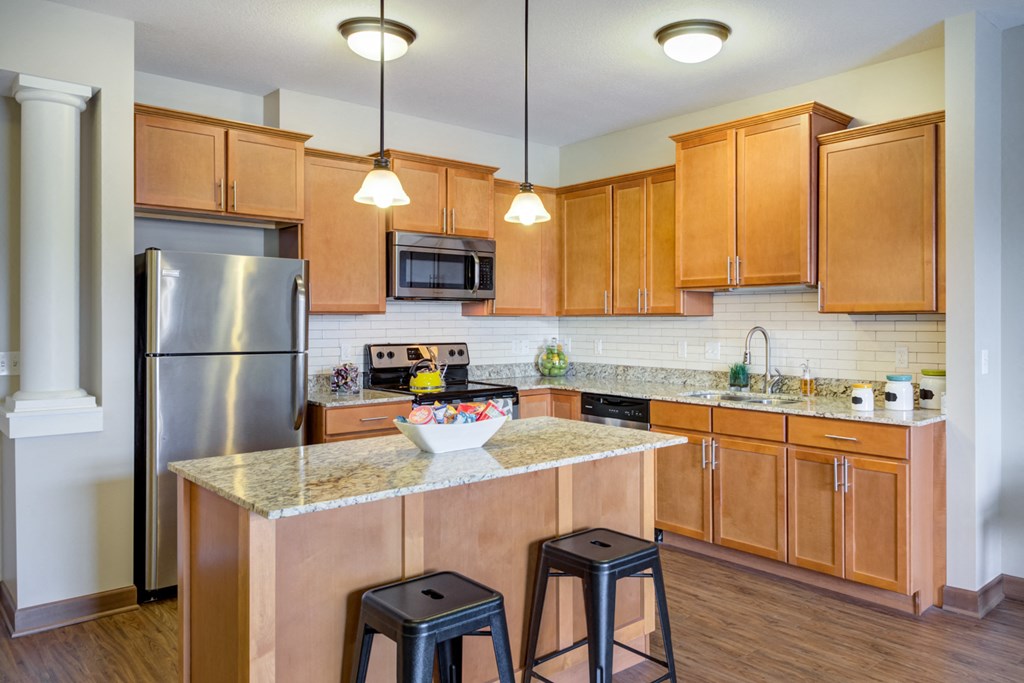 a kitchen with wooden cabinets and a counter top with two stools
