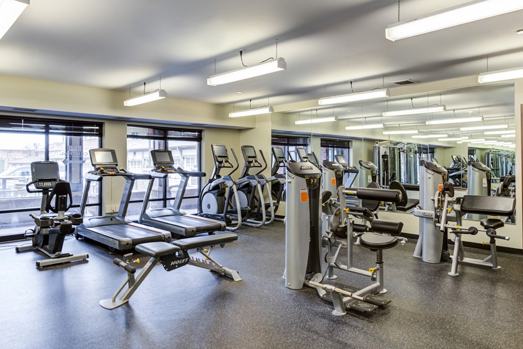 a gym with various cardio machines and weights