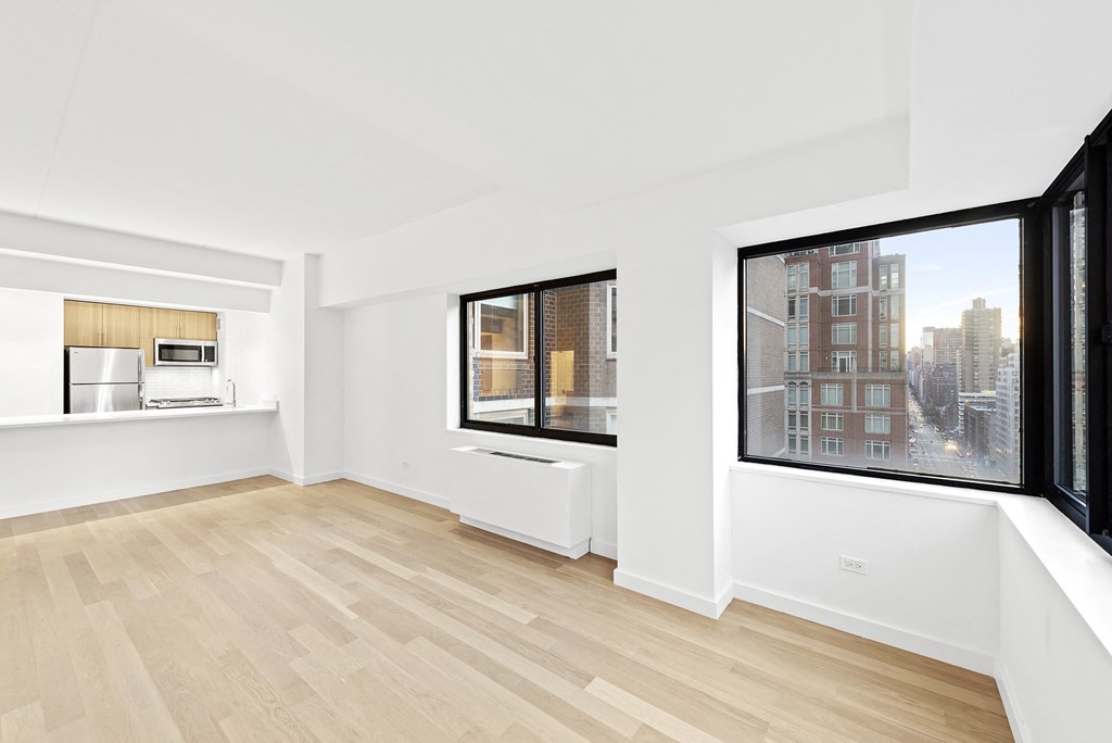 a living room with a large window and a wooden floor