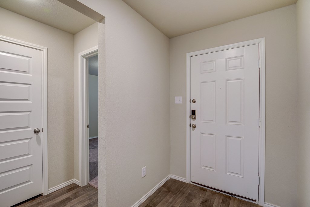 an empty bedroom with a white door and a closet