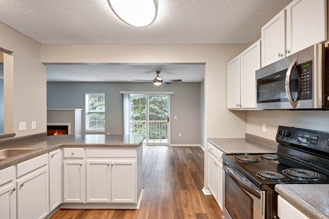 A kitchen with white cabinets and a black stove top oven.