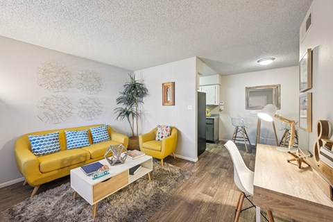 A living room with a yellow sofa and a white coffee table.