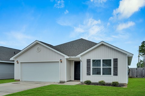 A house with a grey garage door and a black door.