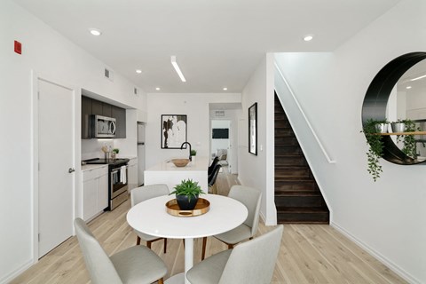 A modern kitchen with a dining table and chairs.