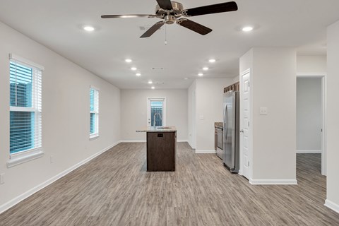 A spacious room with a ceiling fan and wooden flooring.