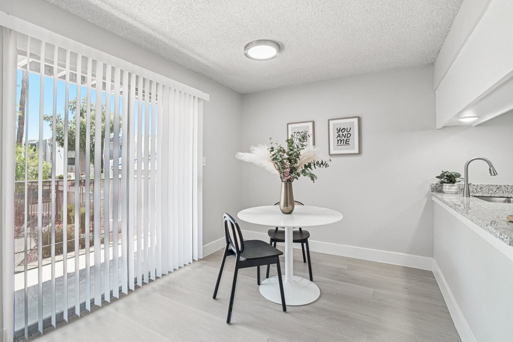 A dining room with a table and chairs.