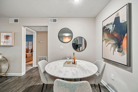 A modern dining room with a white table and chairs.