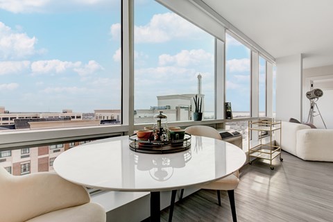 A modern dining room with a table set for two and a view of the city.