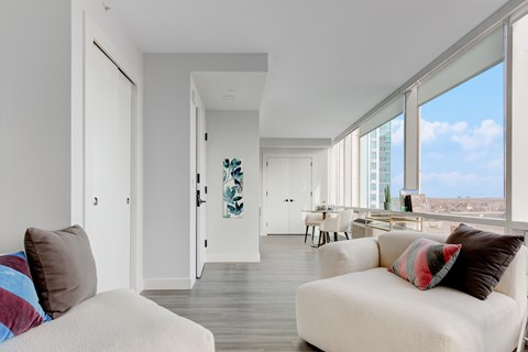 A living room with a white couch and a view of the city.