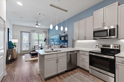 A modern kitchen with stainless steel appliances and white cabinets.