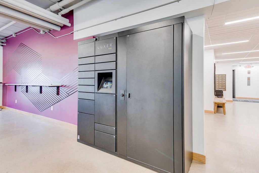 a locker room with a pink wall and a stainless steel door