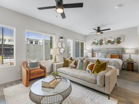 A well-lit, modern living room with a sofa, armchair, and a coffee table.