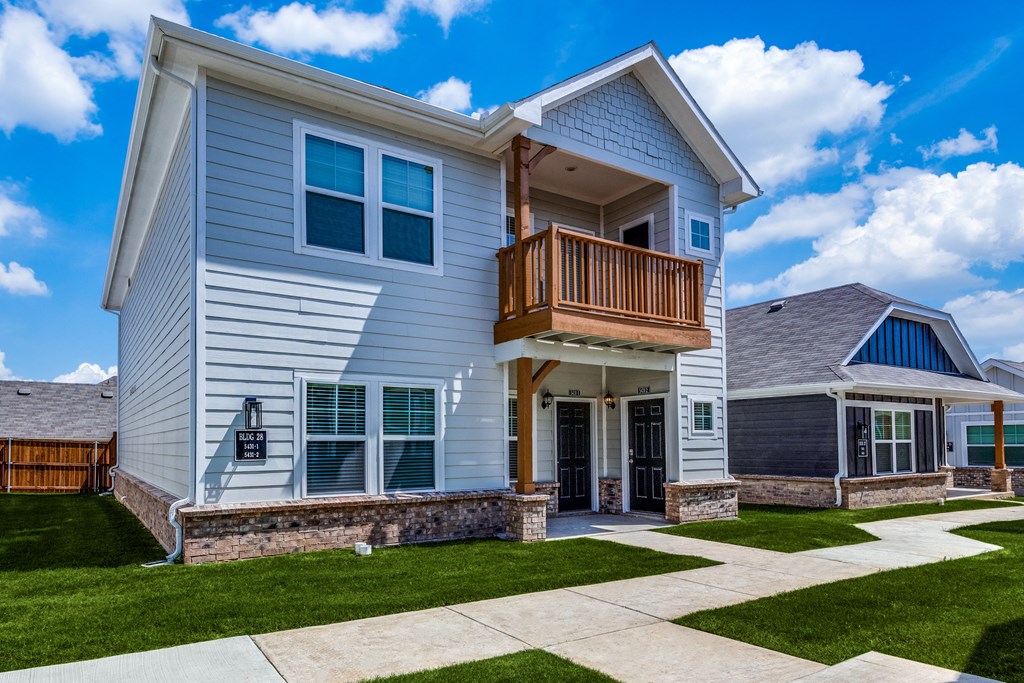 a white house with a balcony on the side of it