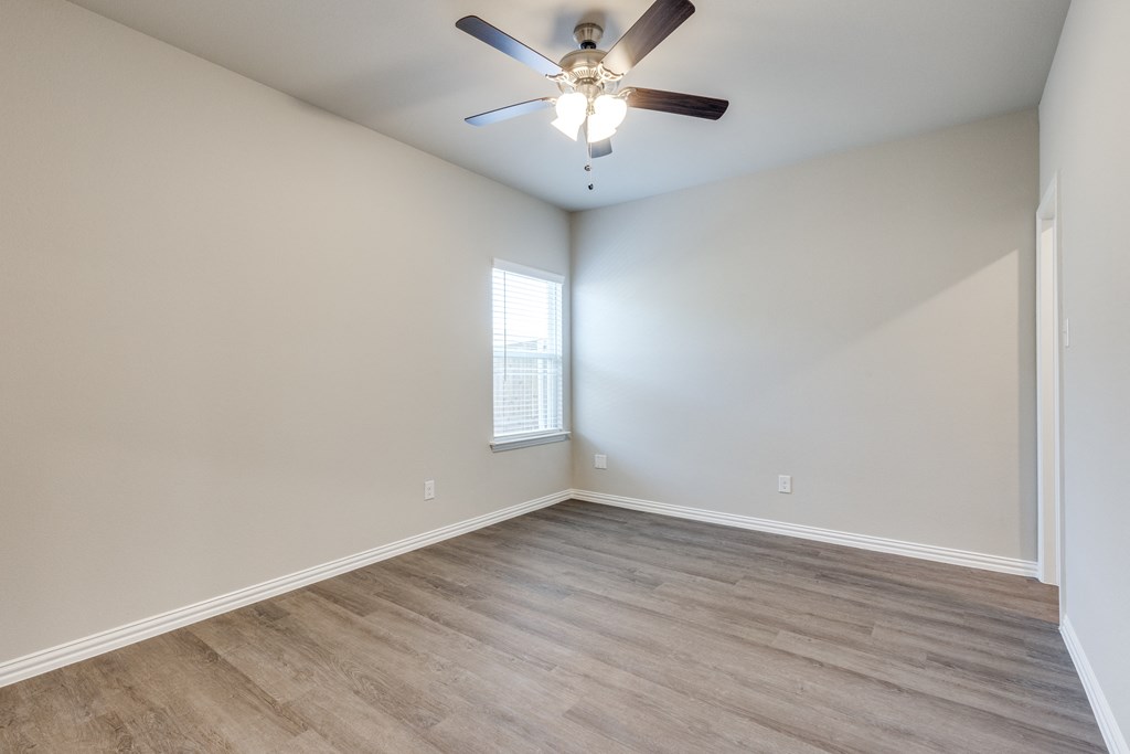 an empty living room with white walls and a ceiling fan