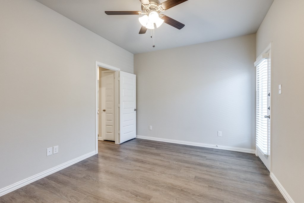 an empty living room with a ceiling fan