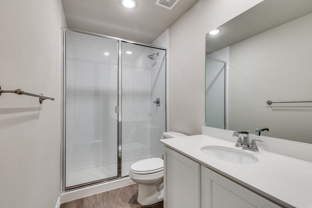 a bathroom with a shower and a sink and a toilet