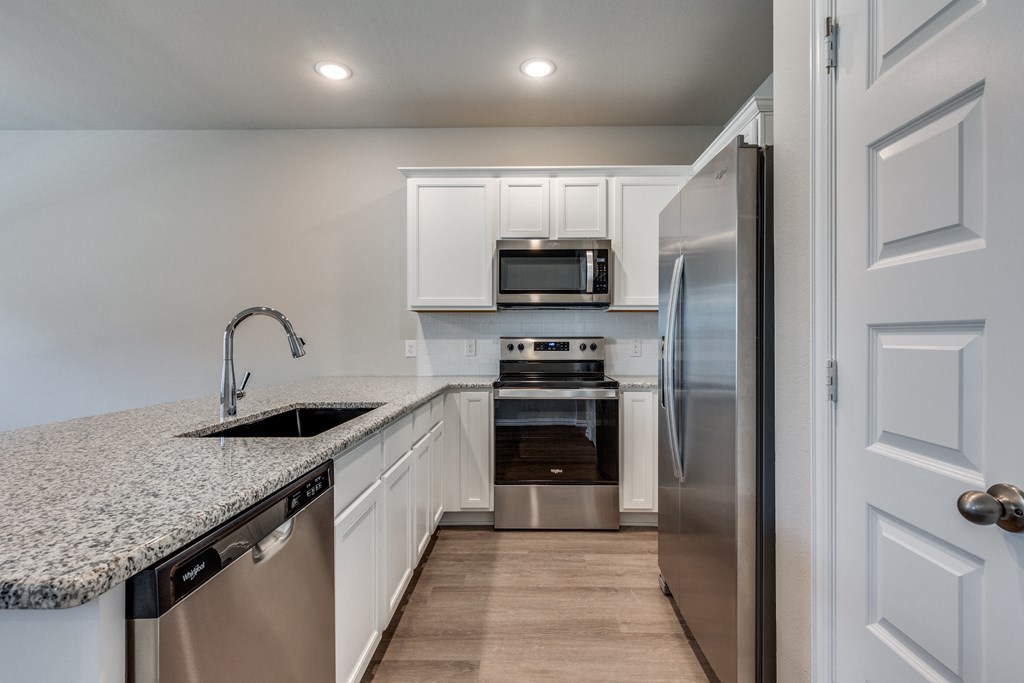 a kitchen with granite counter tops and stainless steel appliances