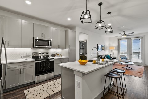A modern kitchen with a large island and bar stools.