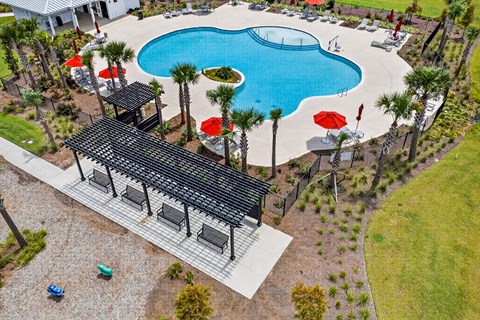 A pool with a black roof and red umbrellas.