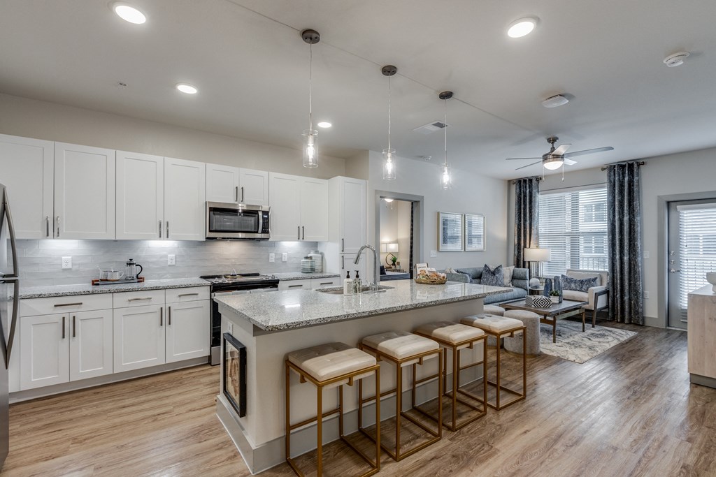 a kitchen and living room with an island and stools