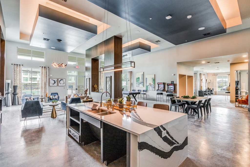 a kitchen with a large island and a living room with tables and chairs