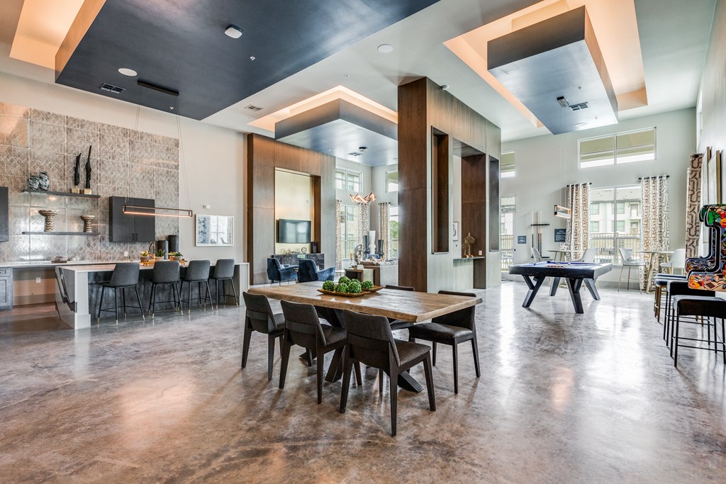 a dining room with a table and chairs and a kitchen with a pool table