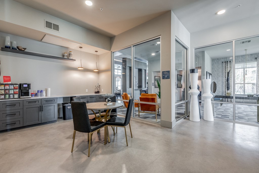 a dining room with a table and chairs and a kitchen with glass doors