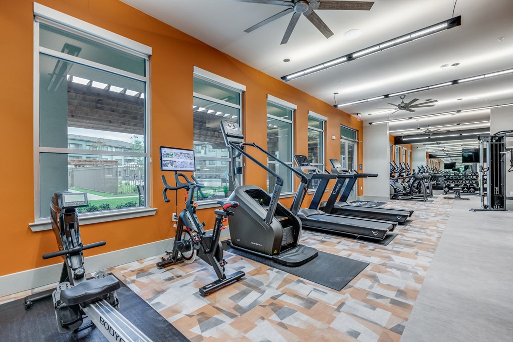 a gym with treadmills and other exercise equipment in the lobby of a building