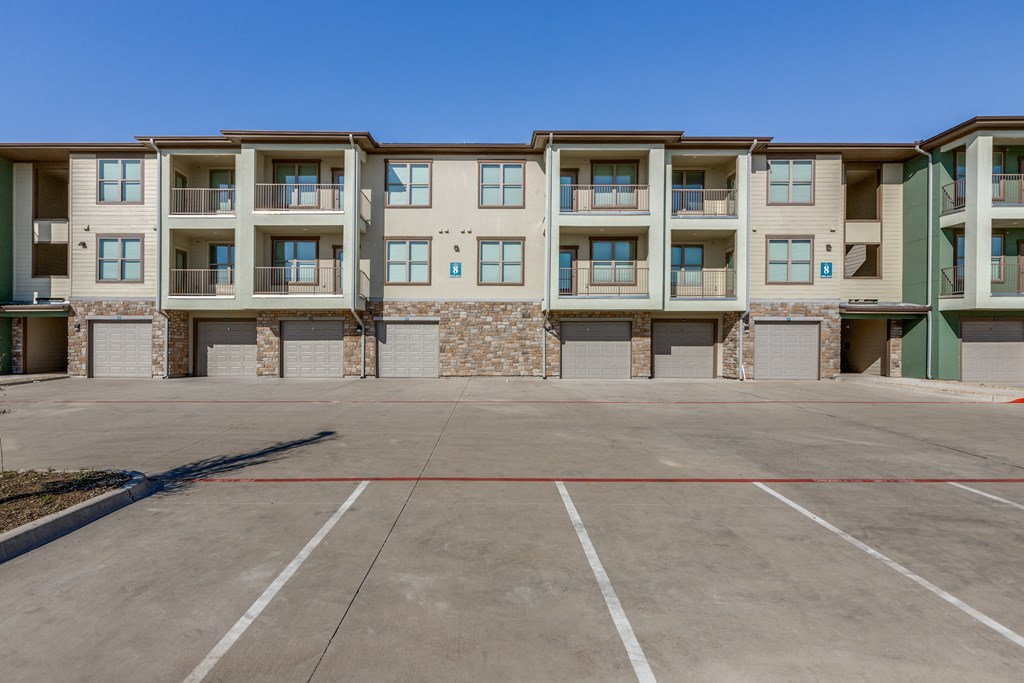 an empty parking lot in front of an apartment building