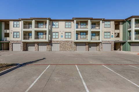an empty parking lot in front of an apartment building